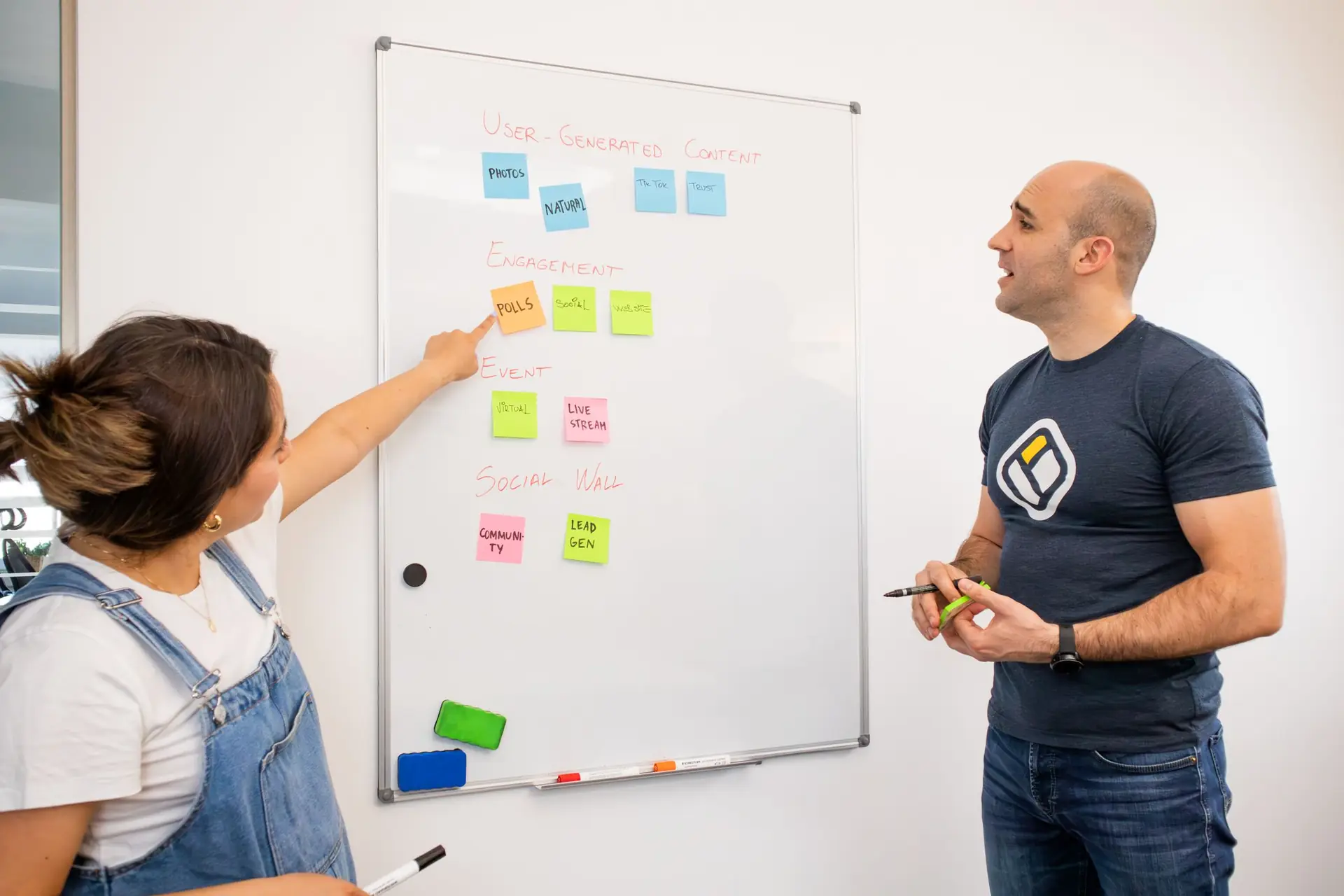 Zwei Gründungspersonen strukturieren ihre Planung mit Notizzetteln an einem Whiteboard